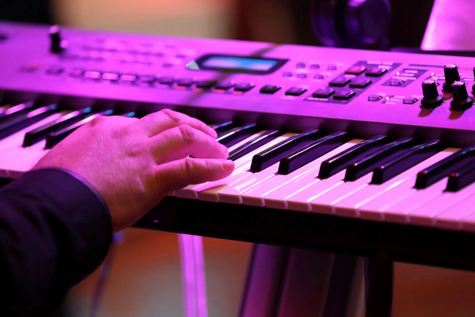 Hand playing an electronic keyboard.