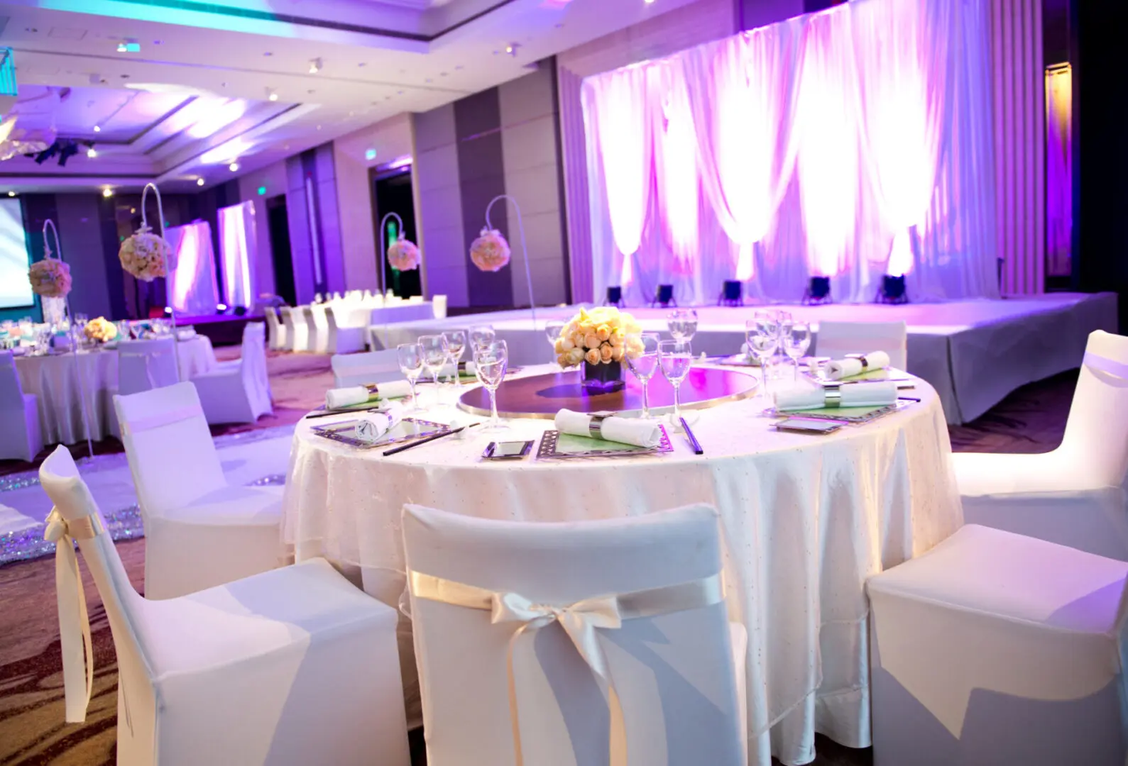 Elegant wedding reception with purple lighting.