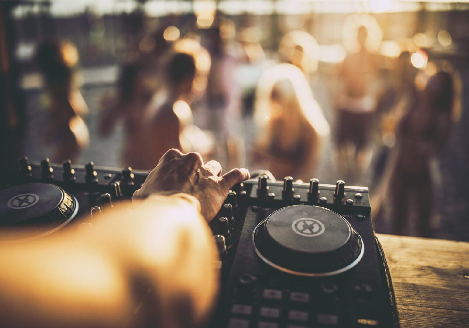DJ mixing music at outdoor party.