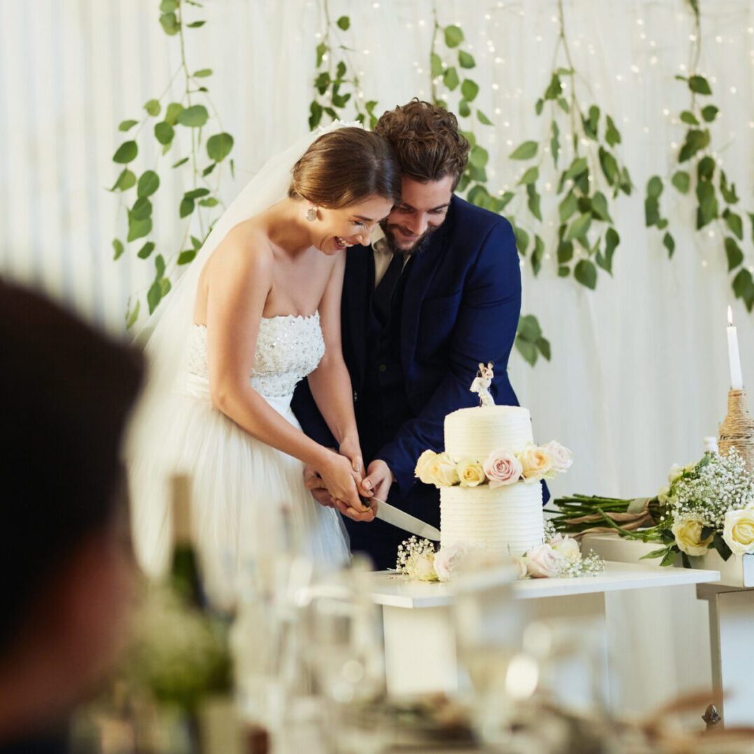 Bride and groom cutting wedding cake together.