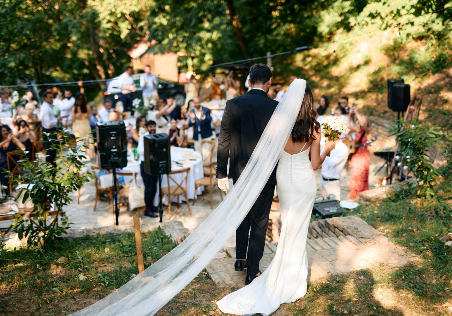 Bride and groom walking at outdoor wedding.